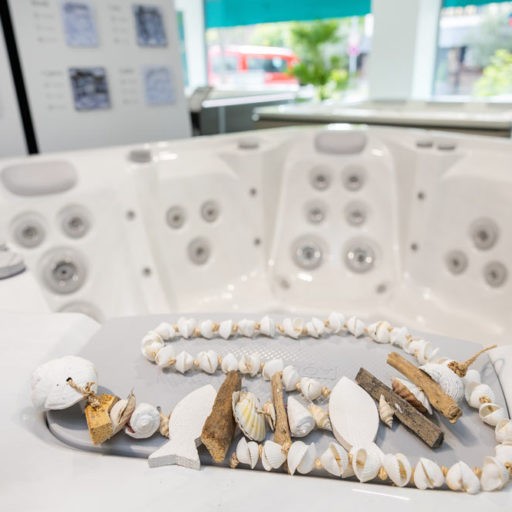 Weiße Whirlpool-Wanne mit Muscheldekoration im Inneren.