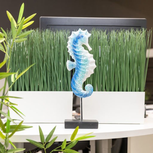 Blaues Seepferdchen-Dekor vor Gras in modernem Büro.