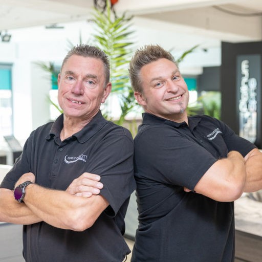 Zwei Männer posieren in einem Geschäft.