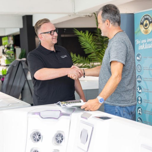 Zwei Männer schütteln Hände im Geschäft.