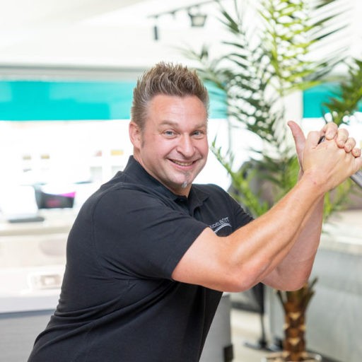 Lächelnder Mann in schwarzem Hemd, Daumen hoch.